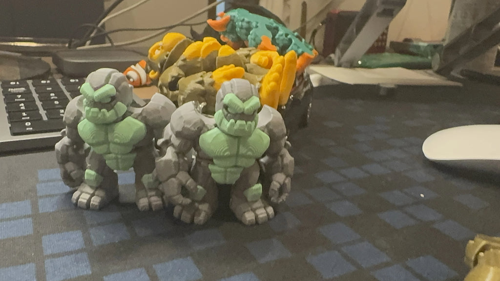 WiggleNest articulated stone golem 3D printed toy in gray and green PLA, professionally displayed with eco-friendly materials and premium craftsmanship. Durable collectible flexi toy, designed and made in Malaysia. 